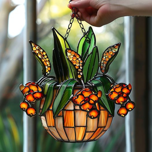 A stunning stained glass planter with bright orange lily flowers 🌿 adds a warm and artistic glow to any room